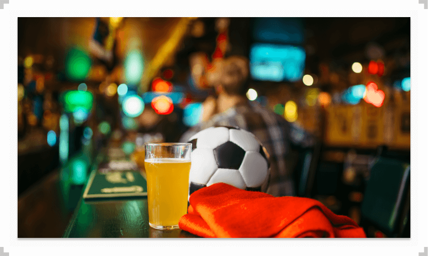 Soccer ball and glass of beer on a bar table