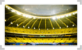Large empty stadium with yellow and blue seats